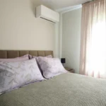 Υπνοδωμάτιο με διπλό κρεβάτι, ταπετσαρισμένο κεφαλάρι και κλιματιστικό